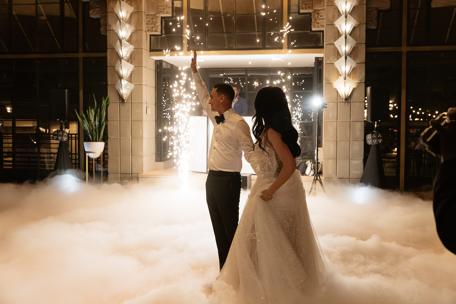 Bride and groom standing together on the dance floor surrounded by fog and sparklers at their Biltmore wedding
