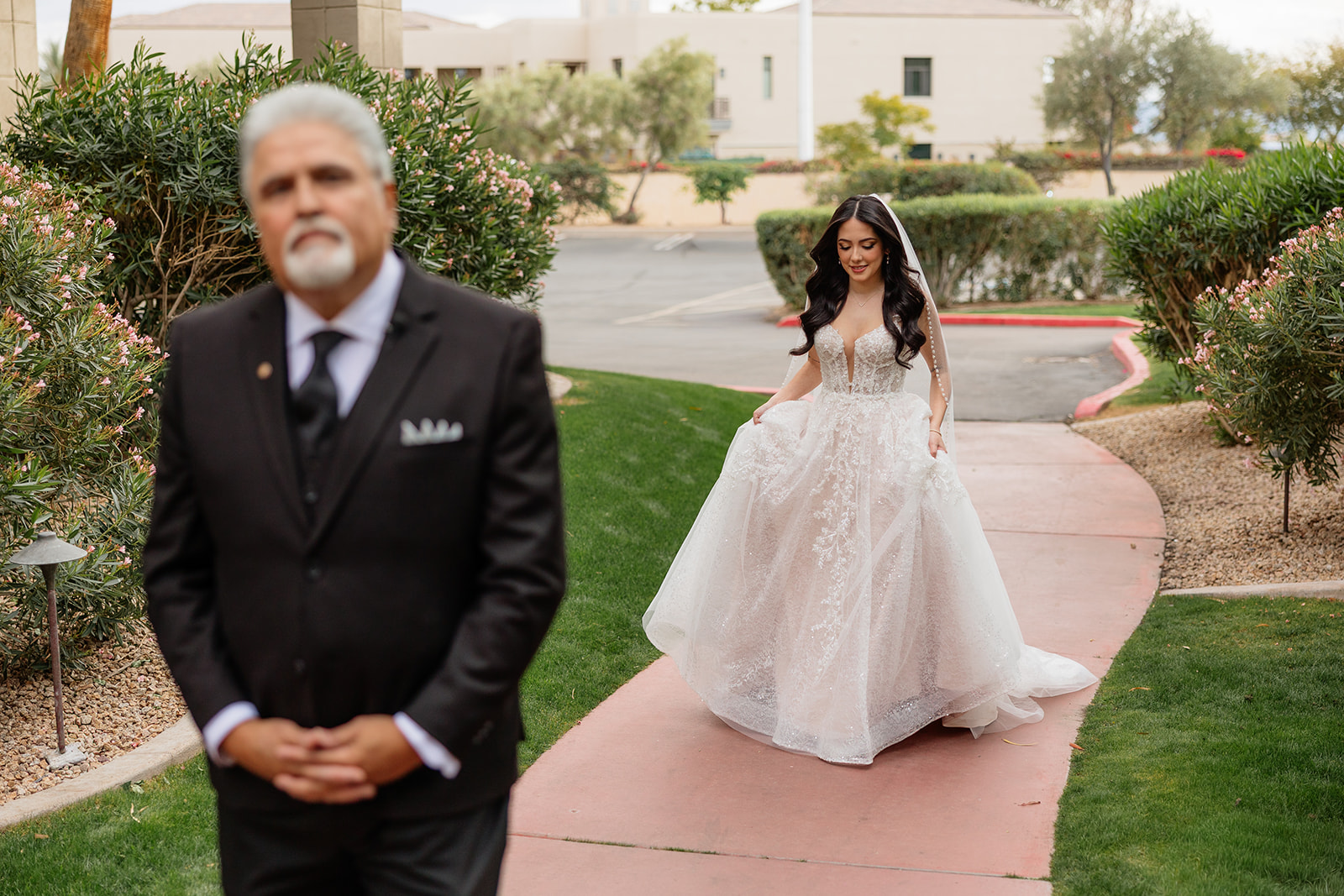 Bride walking toward her father for a first look on a garden path at the Biltmore wedding venue
