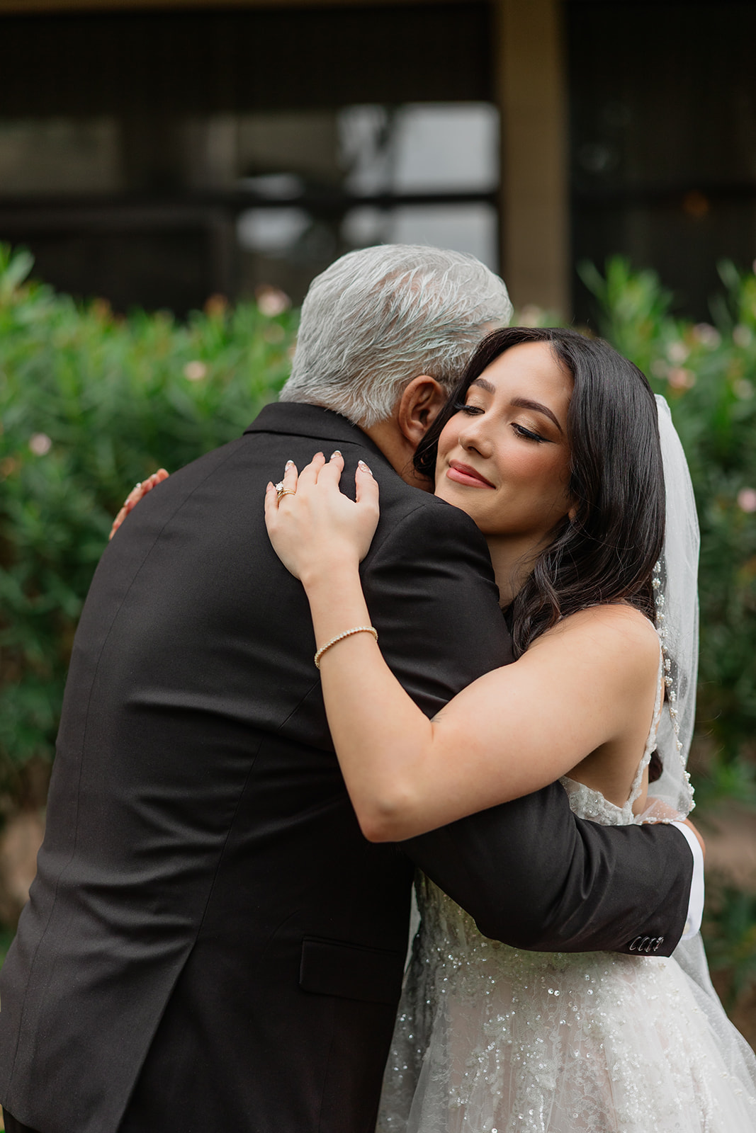 Bride hugging her father tightly during an emotional first look moment
