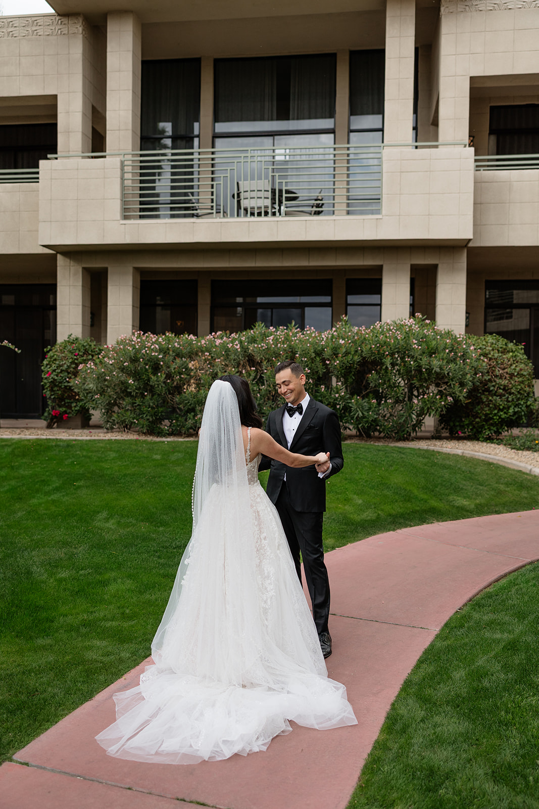 Bride and groom holding hands and laughing together outside the Biltmore wedding venue
