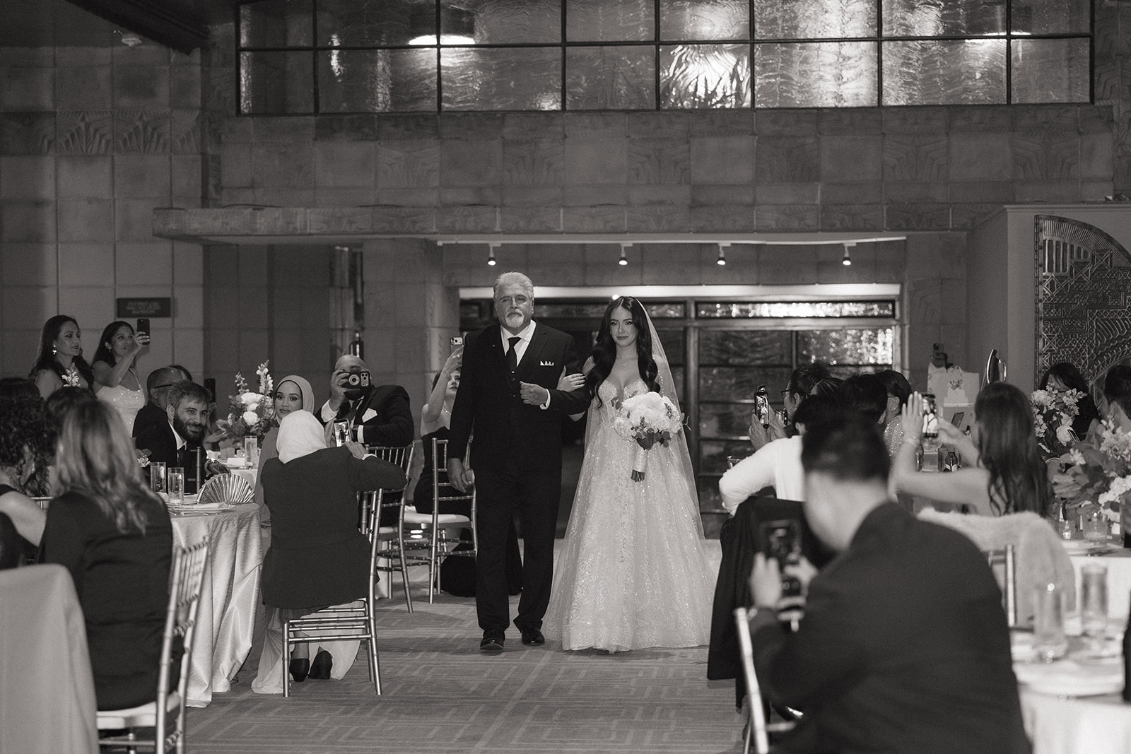 Bride walking down the aisle with her father as guests watch from their seats during the Biltmore wedding reception
