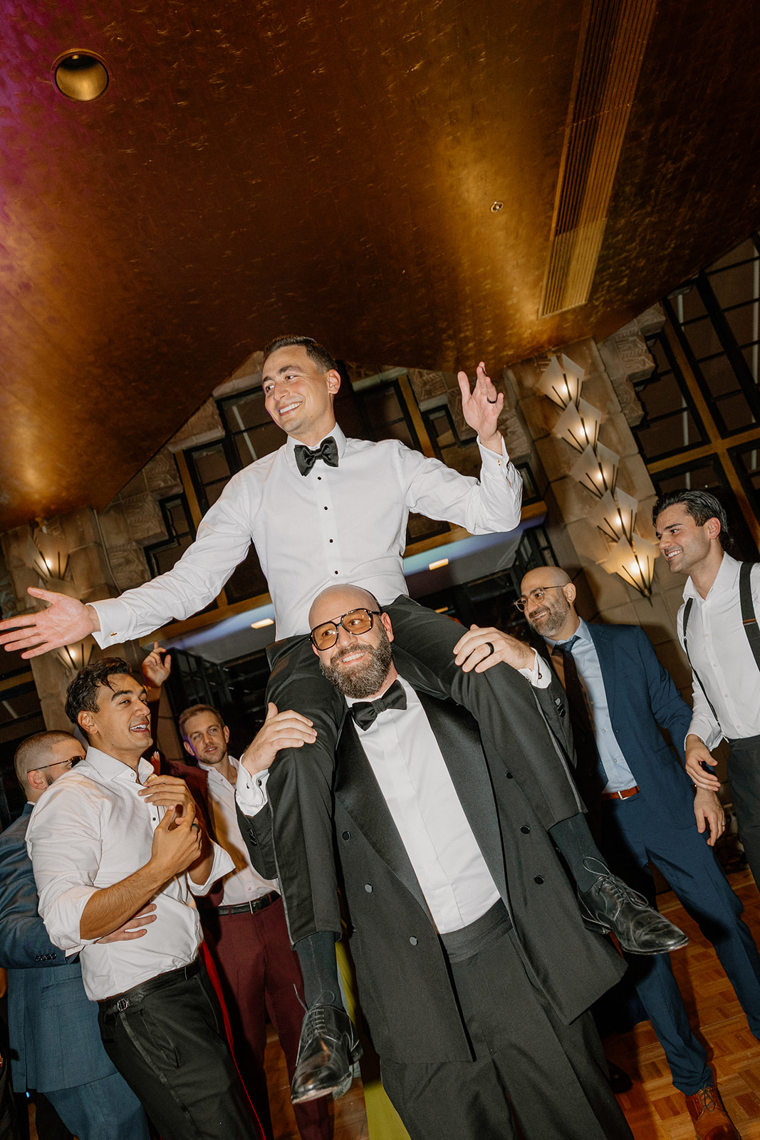 Groom lifted onto shoulders by friends on the dance floor during a high-energy Biltmore wedding reception
