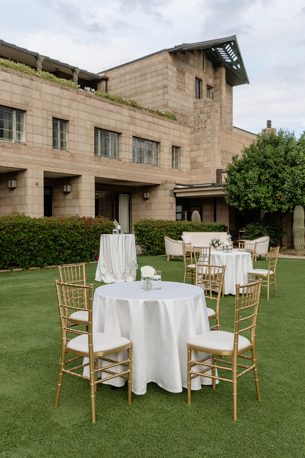 Outdoor reception setup with cocktail tables and gold chairs on the lawn at the Biltmore wedding venue
