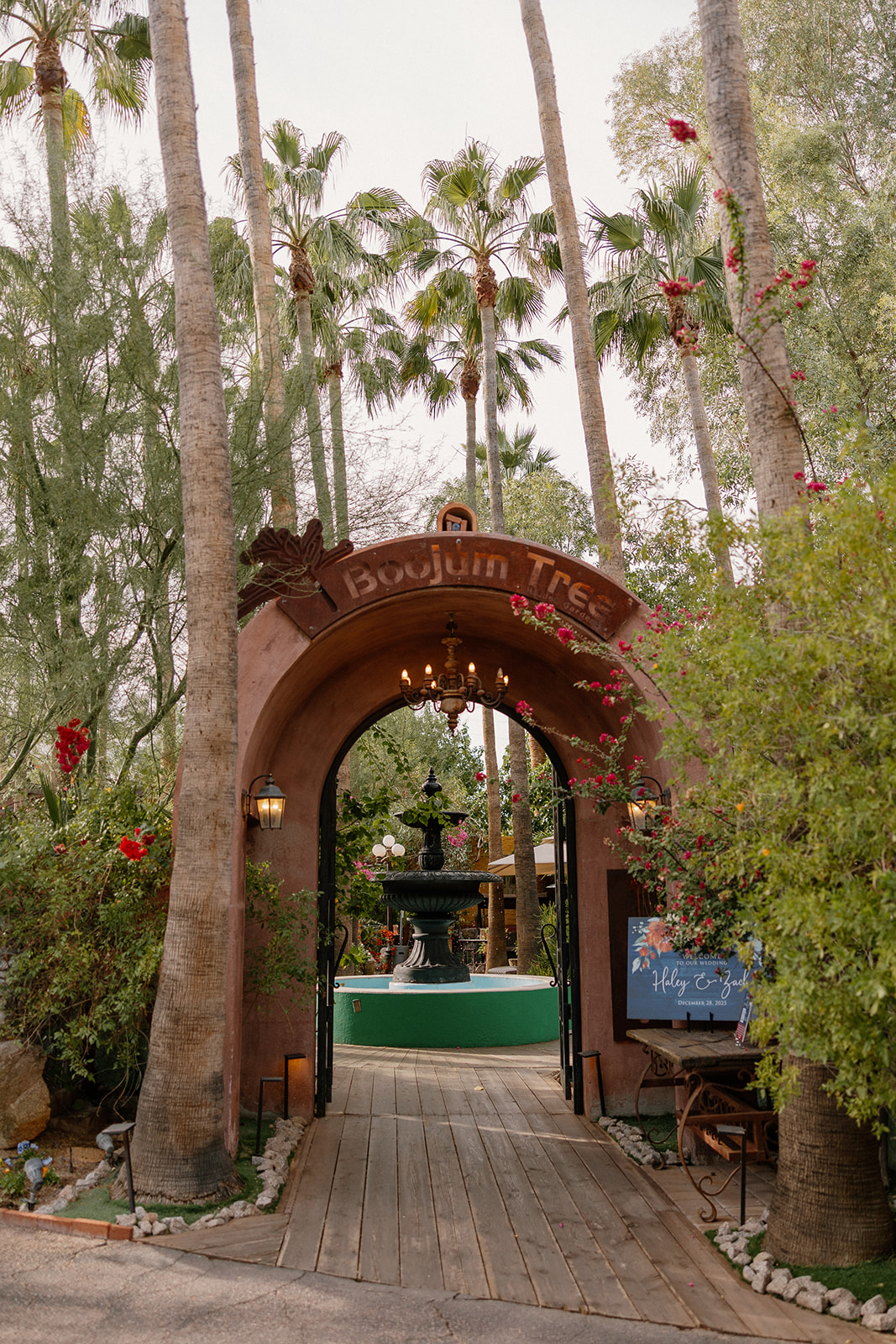 Entrance arch to Boojum Tree Gardens wedding venue with palm trees and fountain courtyard
