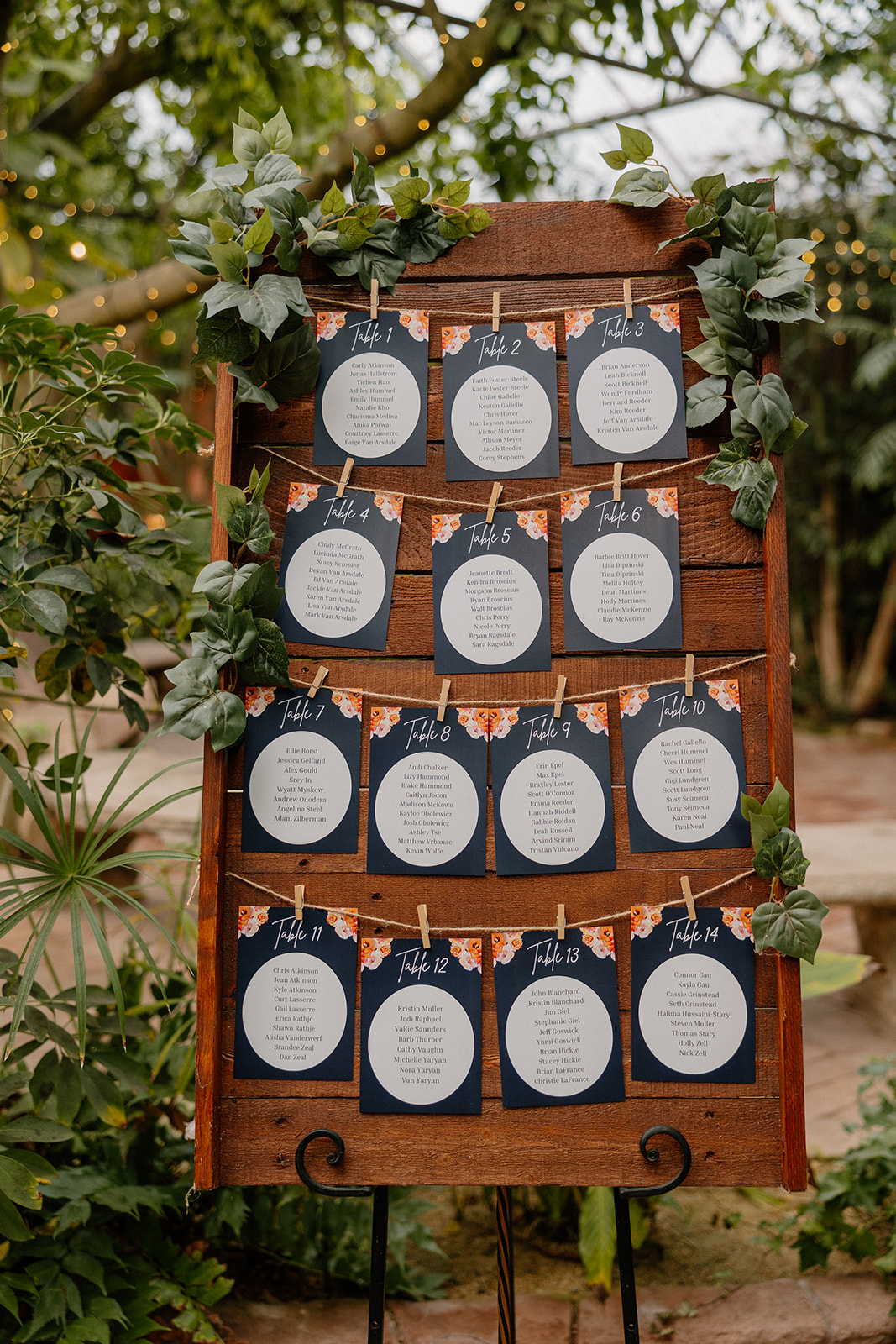 Wedding seating chart display on wooden board with greenery at Arizona wedding venues
