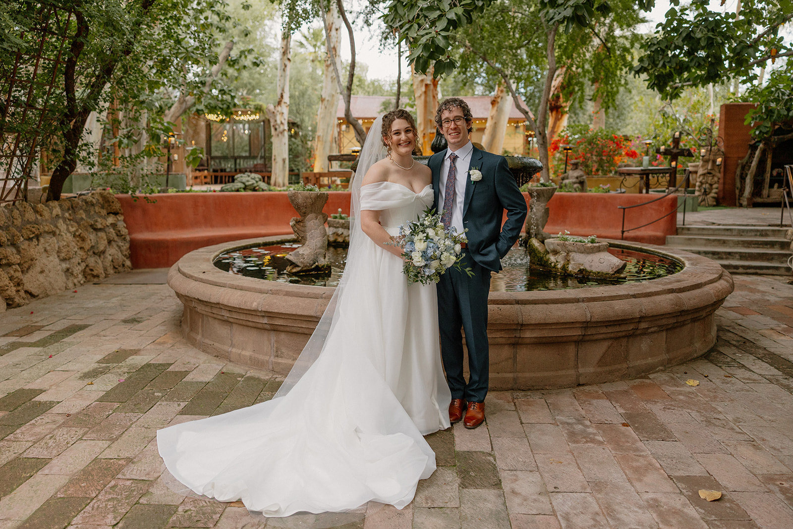 Bride and groom posing in front of fountain at Boojum Tree Gardens in Phoenix Arizona
