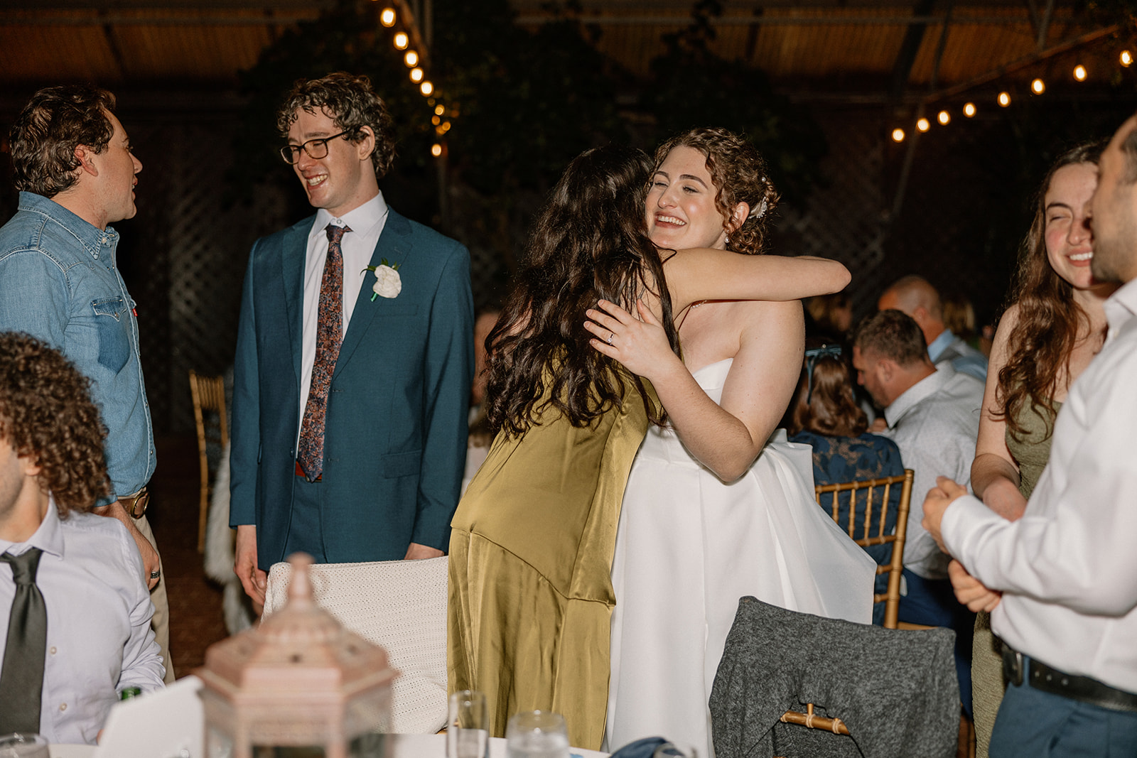 Bride hugging guest during lively reception celebration at Arizona wedding venues with intimate indoor setting
