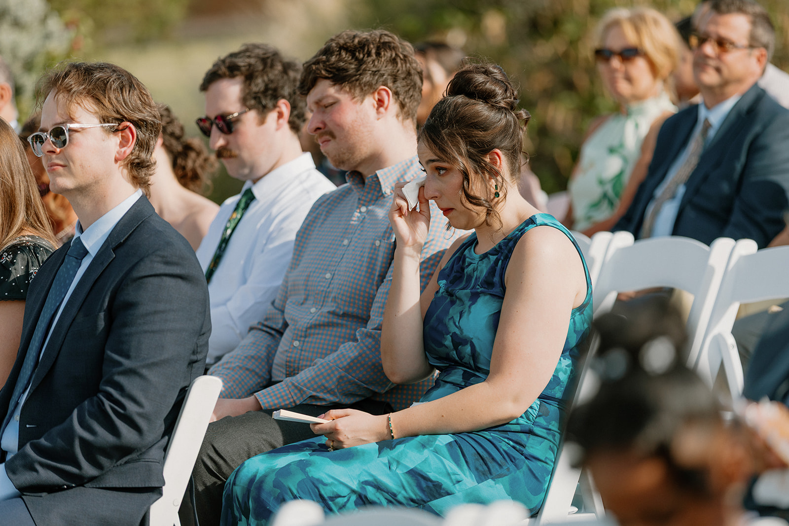 wedding guest wiping tears during emotional ceremony moment