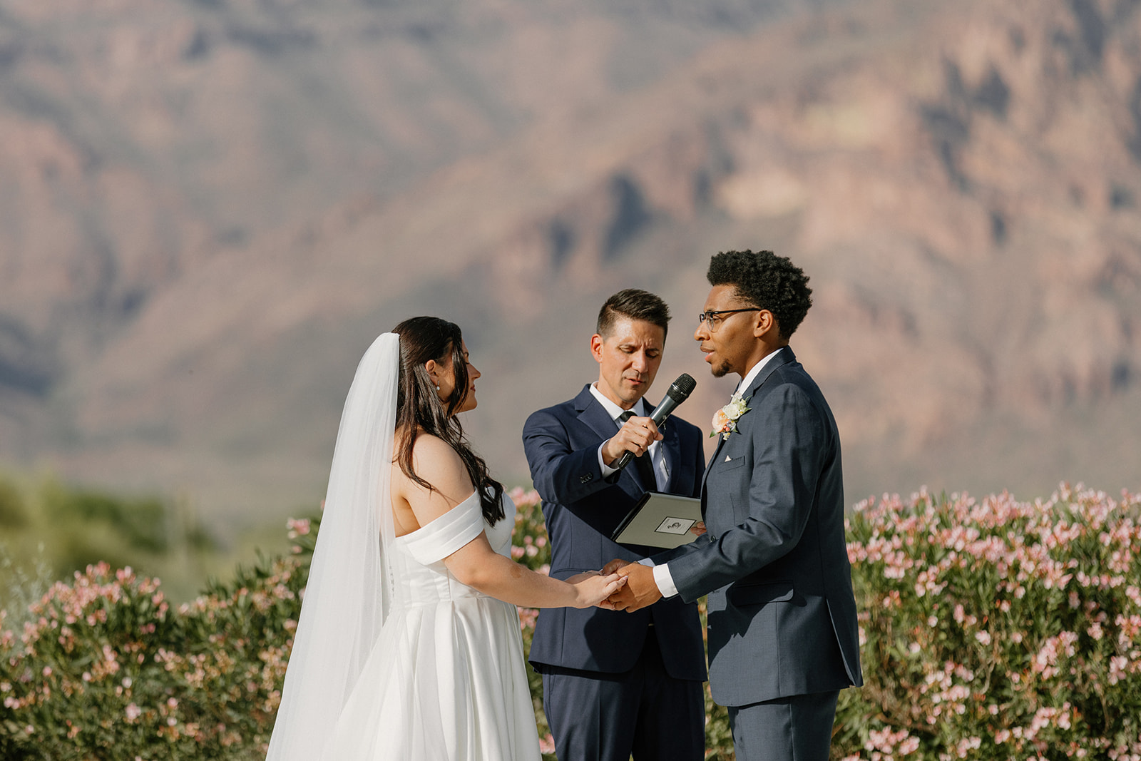 close up of couple holding hands during ceremony vows outdoors