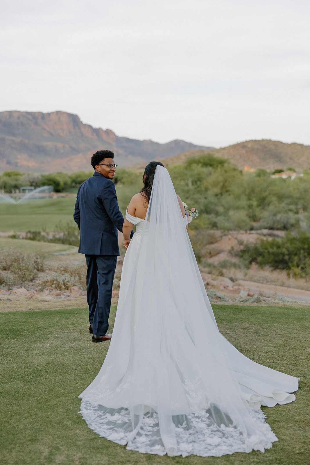 bride and groom standing together with mountain views during outdoor ceremony at gold canyon golf resort wedding