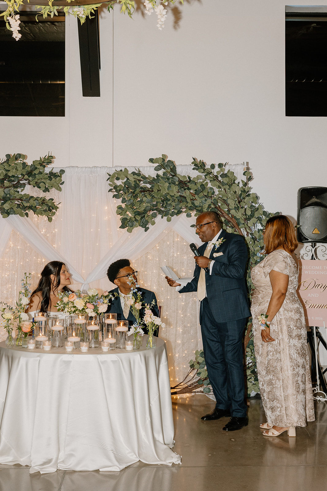 father giving speech during reception with bride and groom seated at gold canyon golf resort wedding