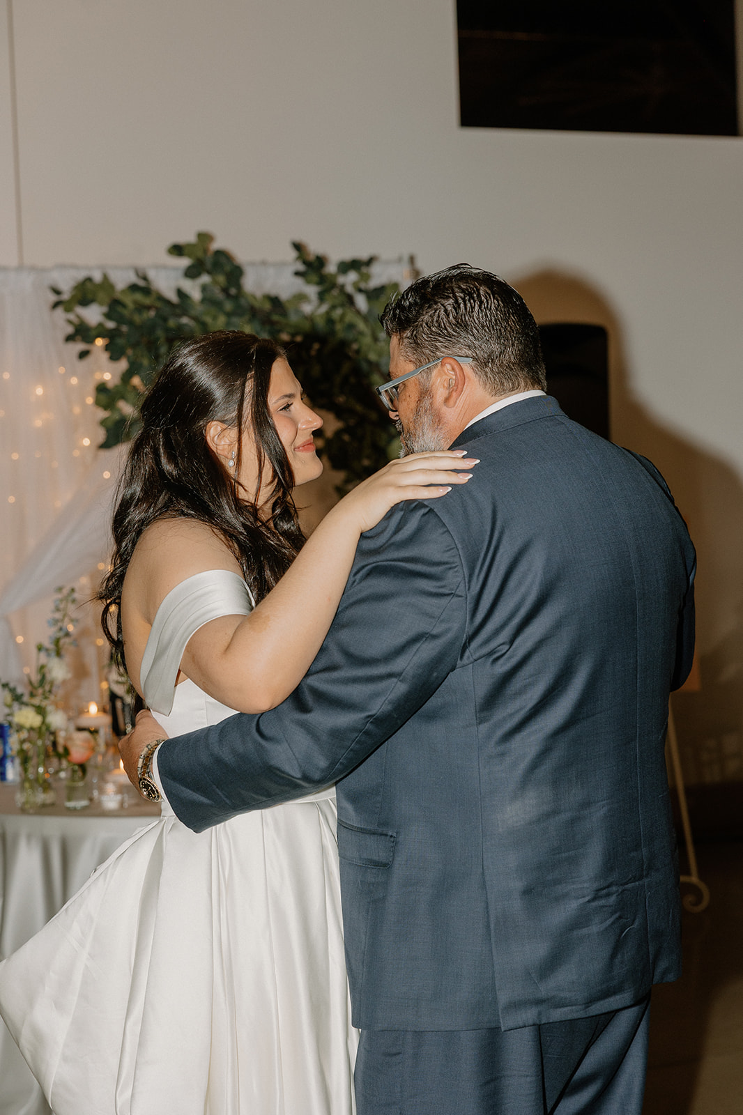 bride dancing with father during reception under soft lighting