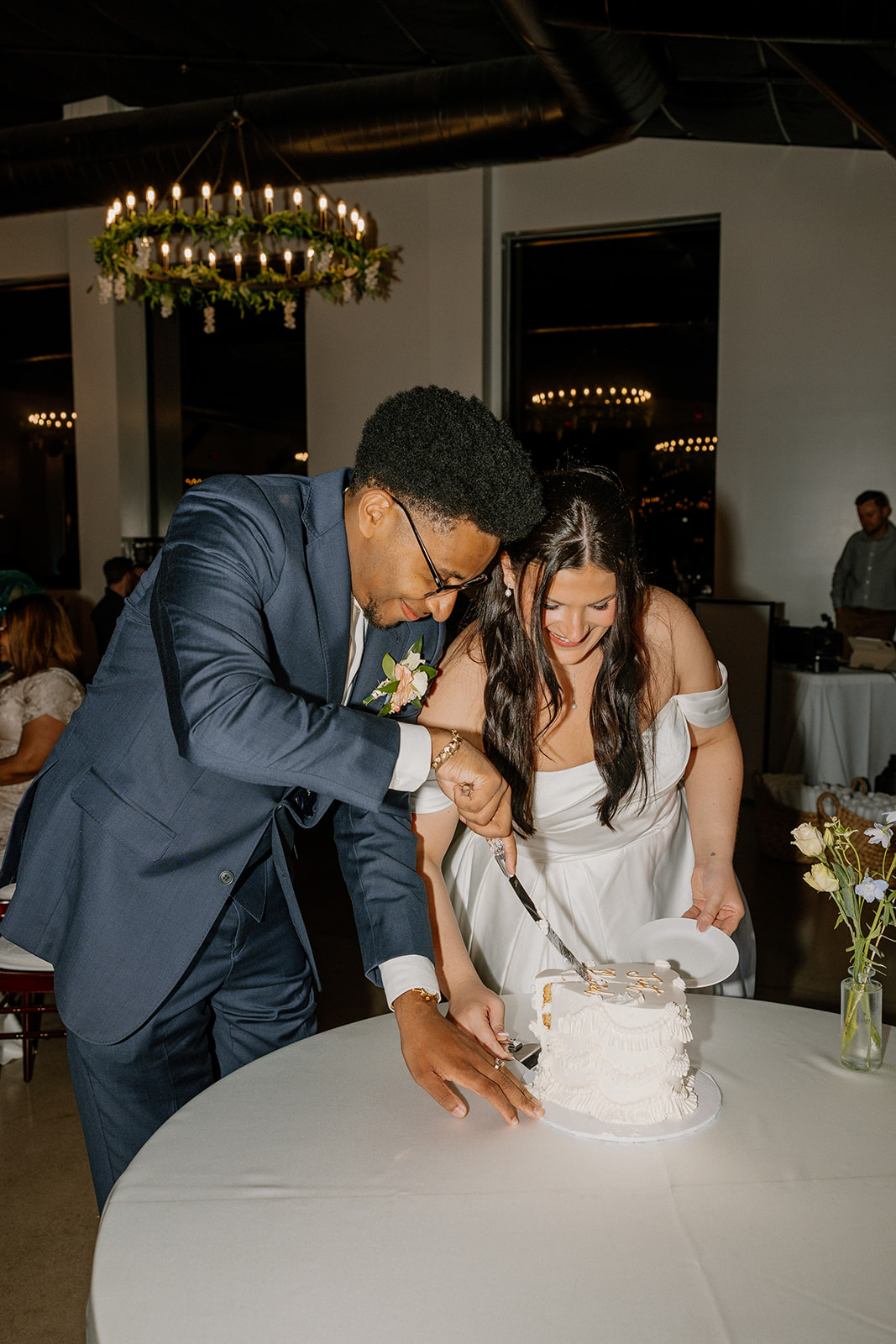 bride and groom cutting wedding cake together during reception