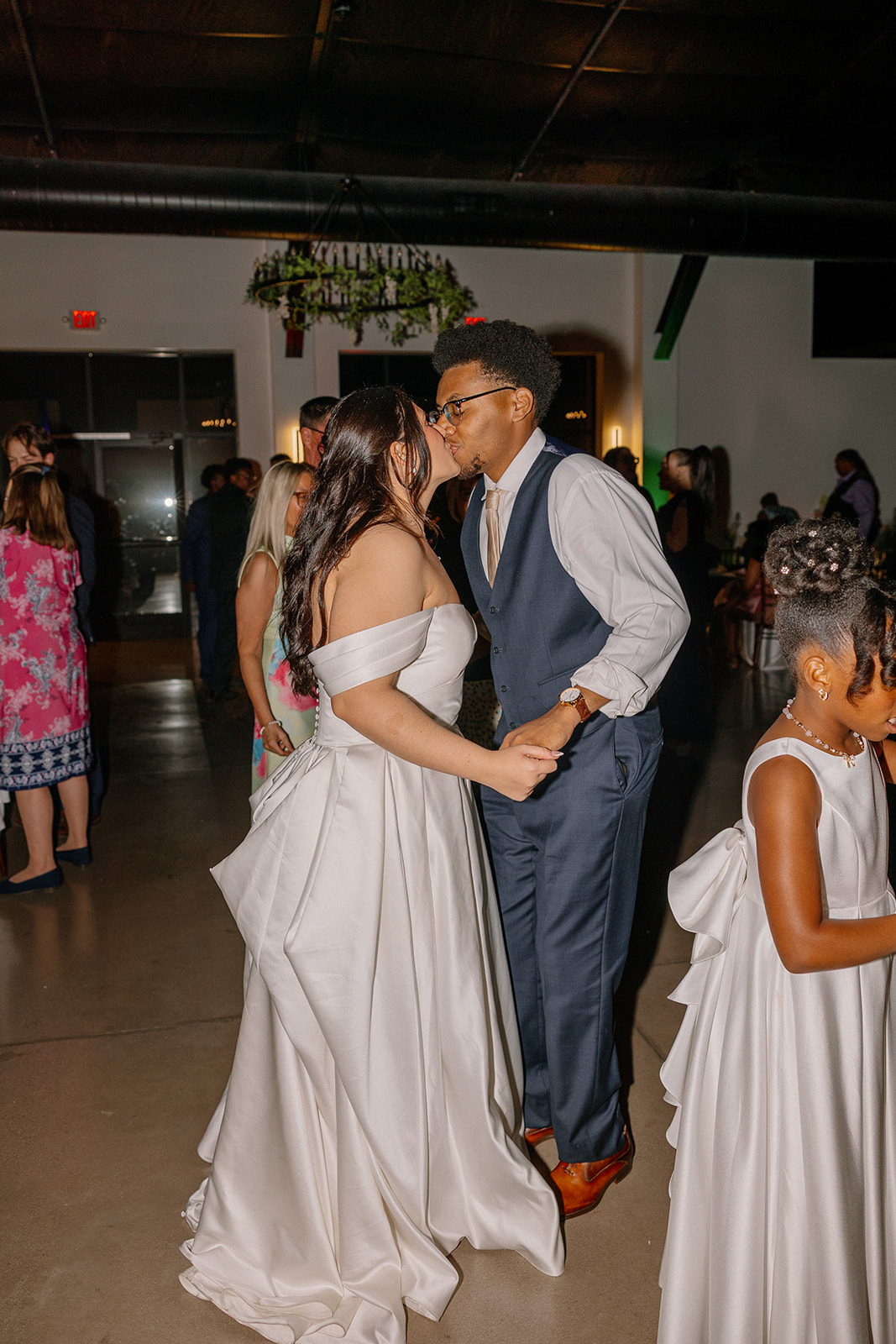 bride and groom dancing together during reception with guests around them