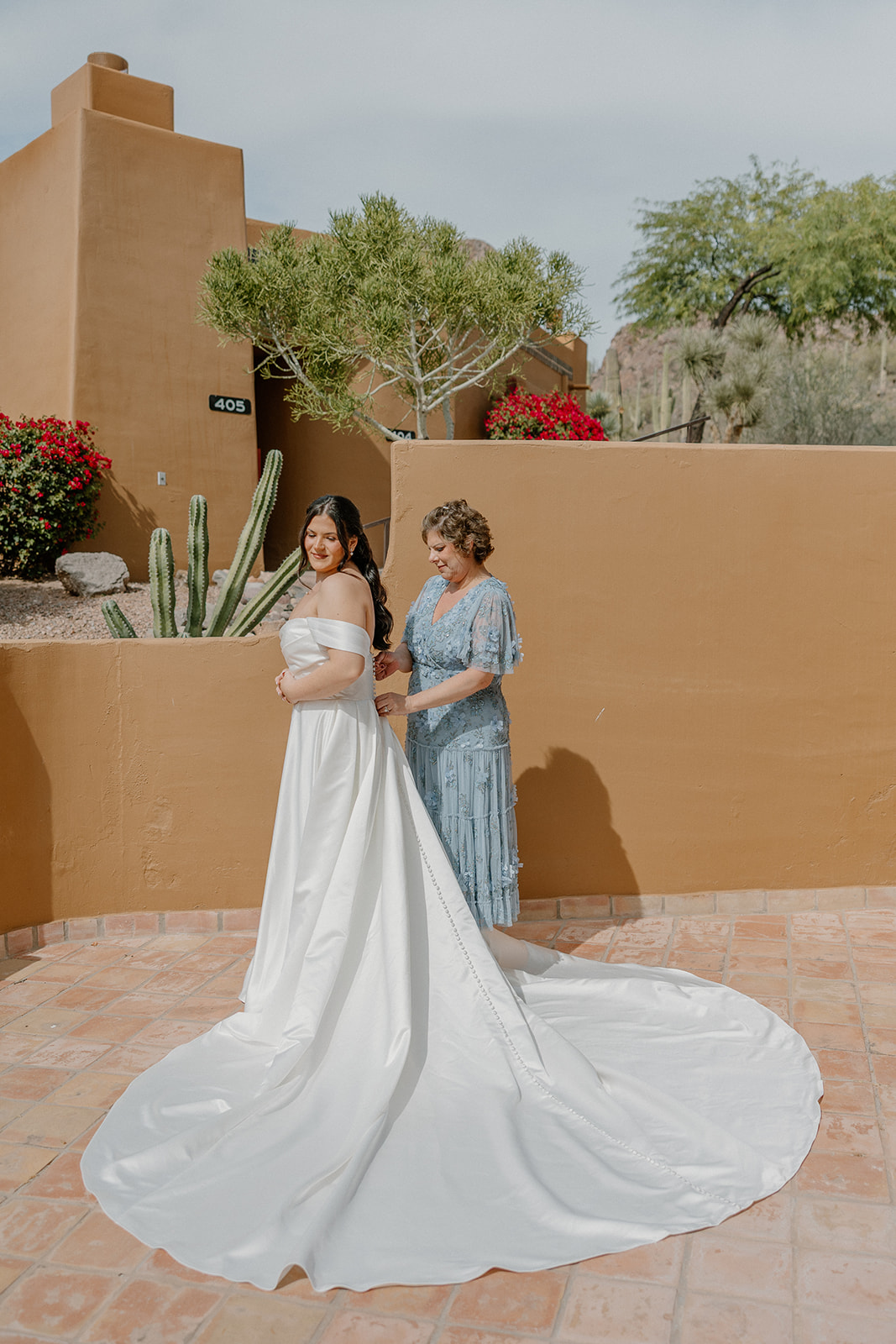 bride standing with family member outdoors in courtyard with desert architecture at gold canyon golf resort wedding