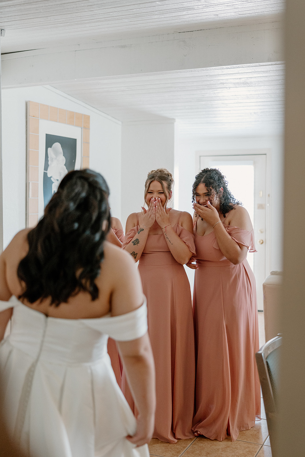 bridesmaids reacting during first look moment indoors with natural light