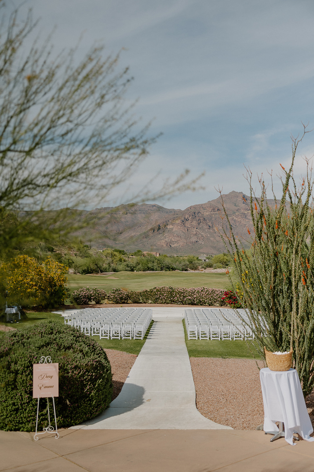 wide view of ceremony space with white chairs and desert mountains at gold canyon golf resort wedding