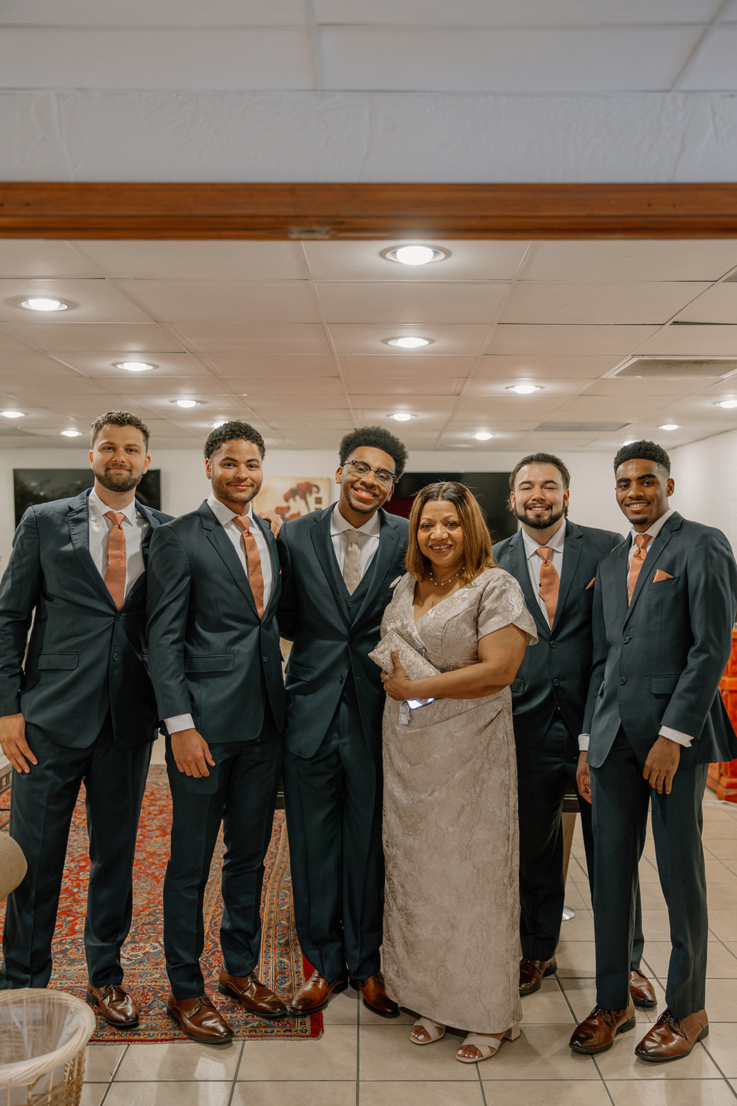 groom posing with family members before ceremony indoors at gold canyon golf resort wedding