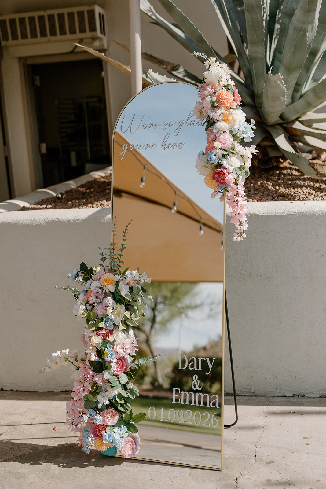 mirror welcome sign with floral details displayed at gold canyon golf resort wedding