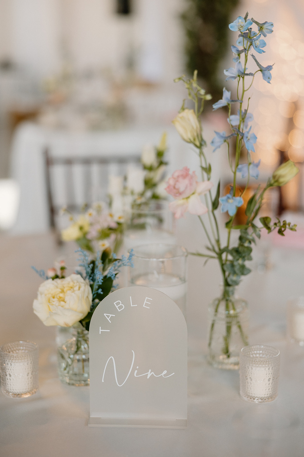 reception table decor with floral centerpieces and table number sign