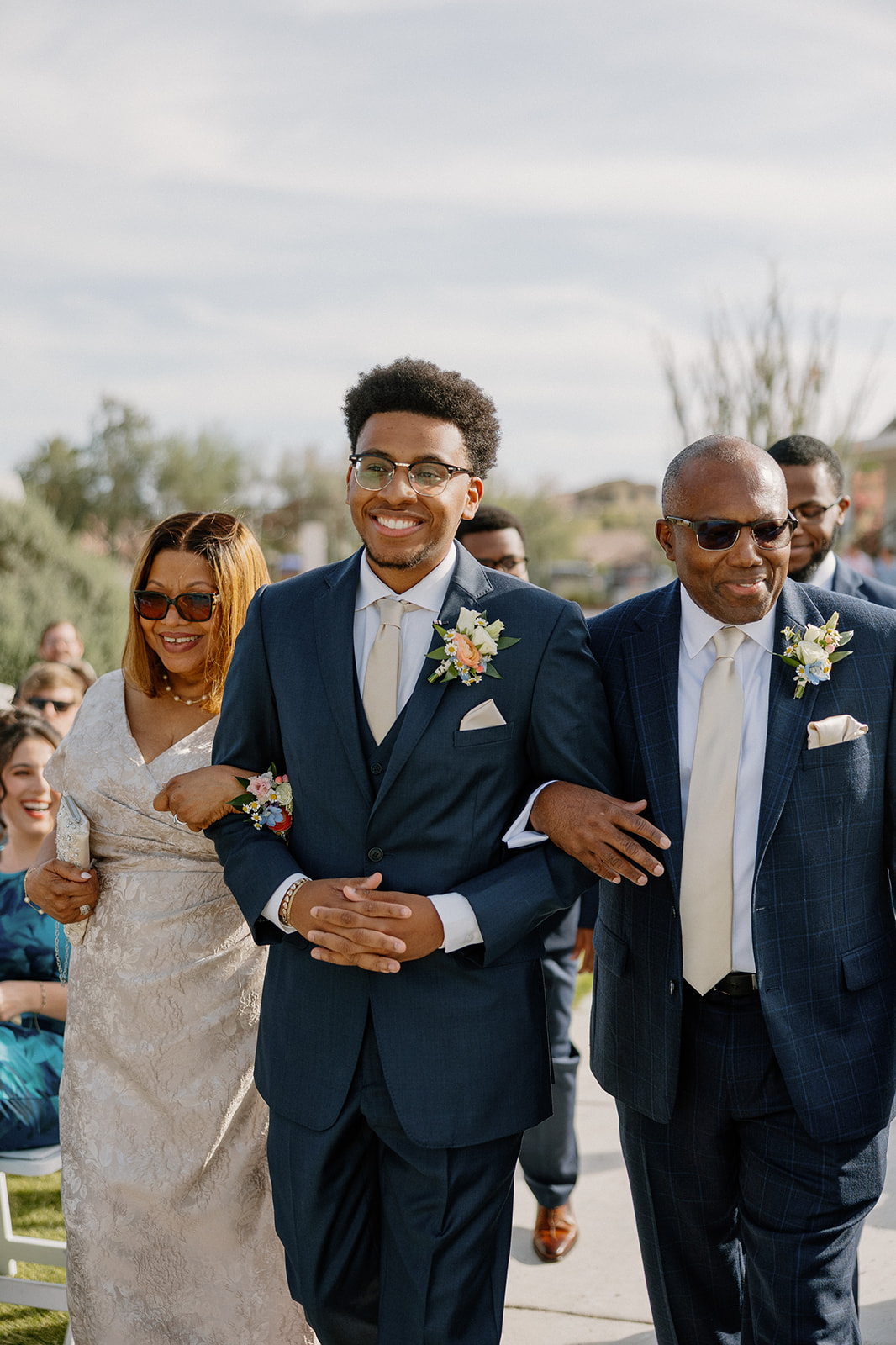groom walking down aisle with parents before ceremony at gold canyon golf resort wedding
