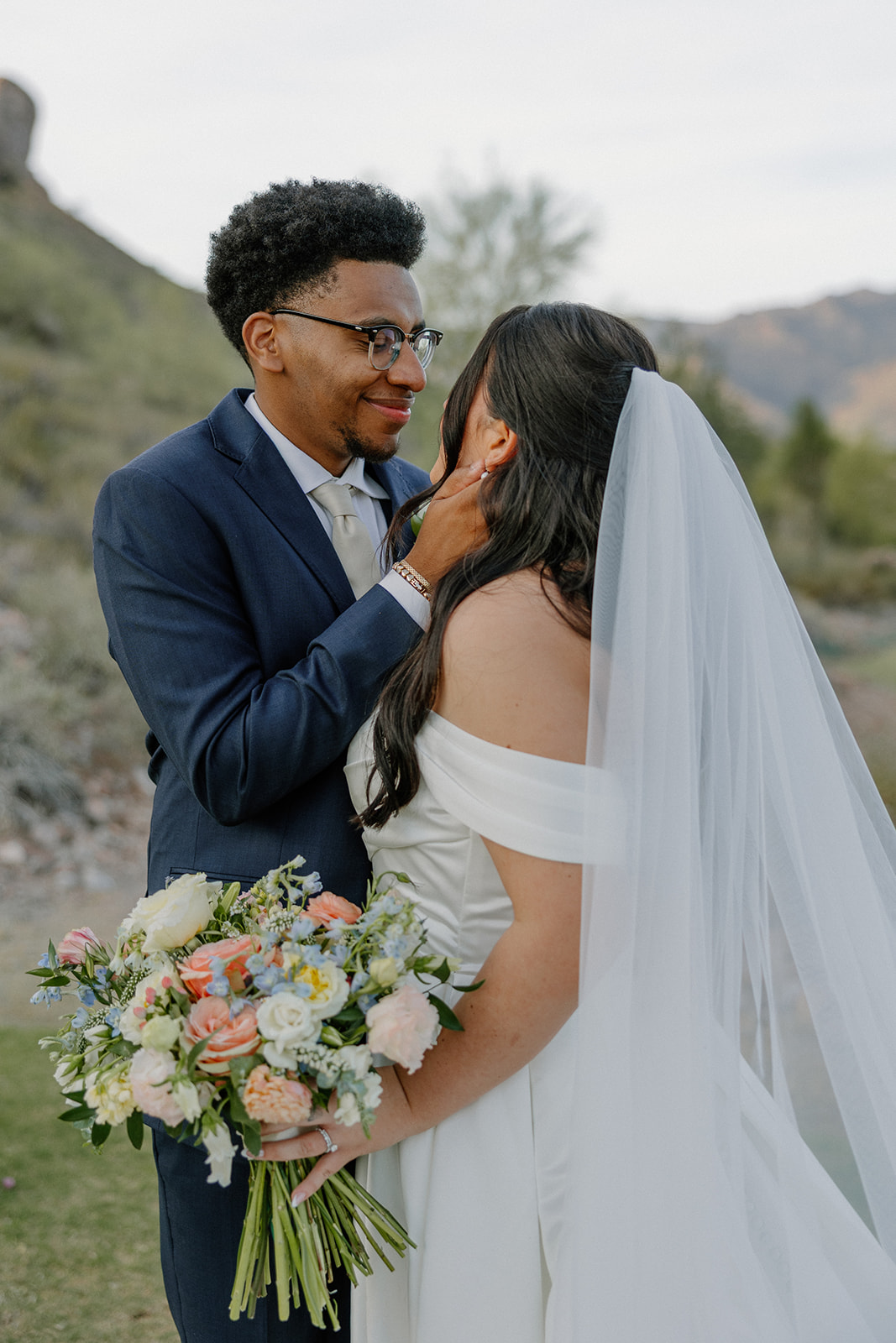 bride and groom holding each other closely with bouquet during golden hour portraits