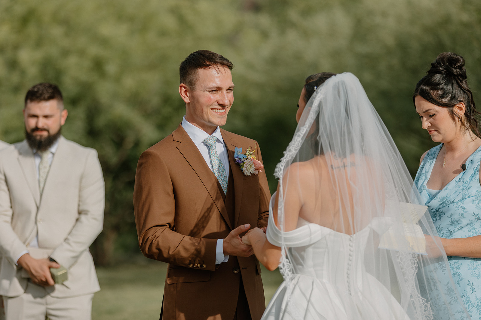 A groom smiling during a wedding ceremony