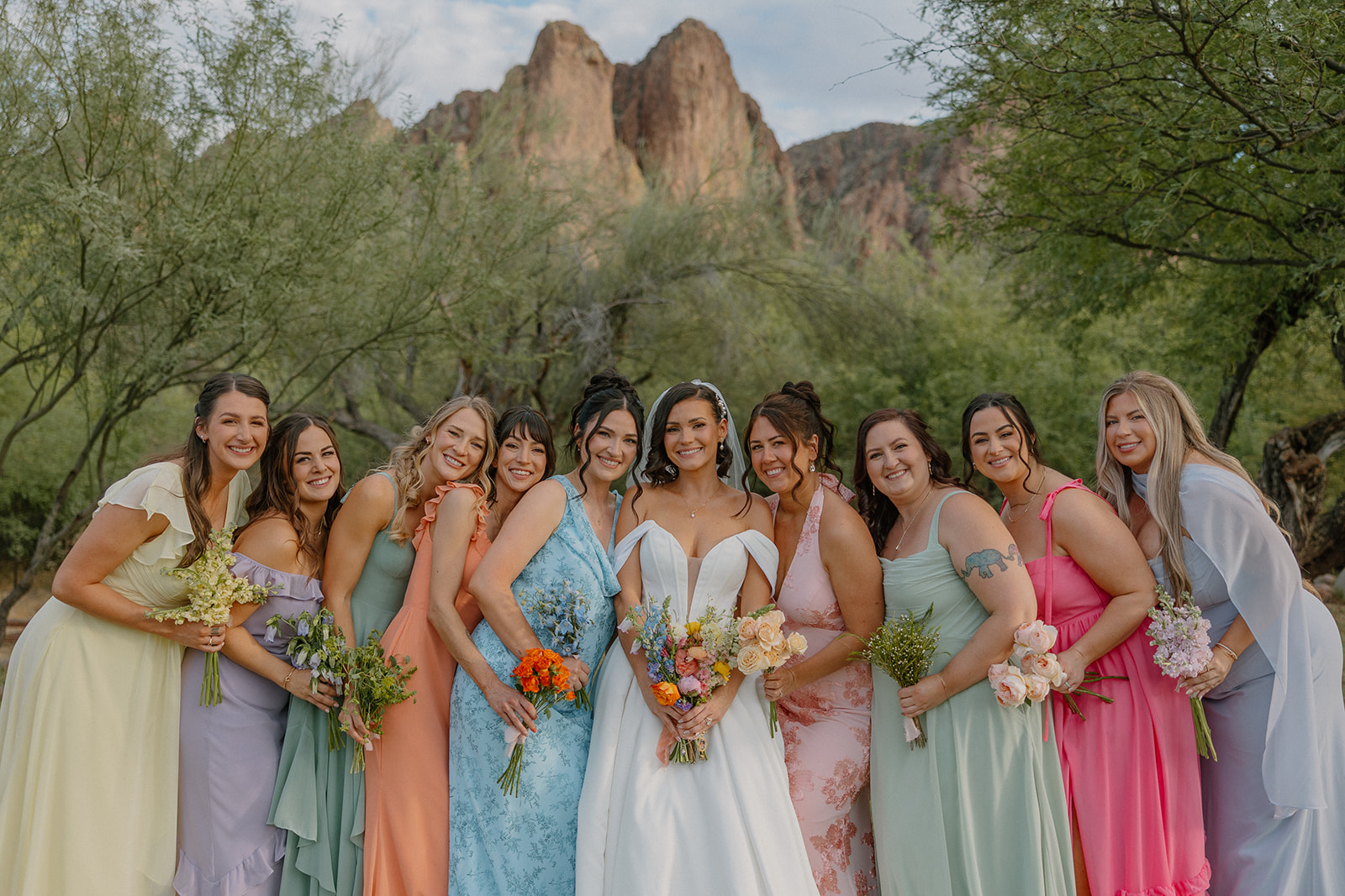 A bride posing for photos with her bridesmaids