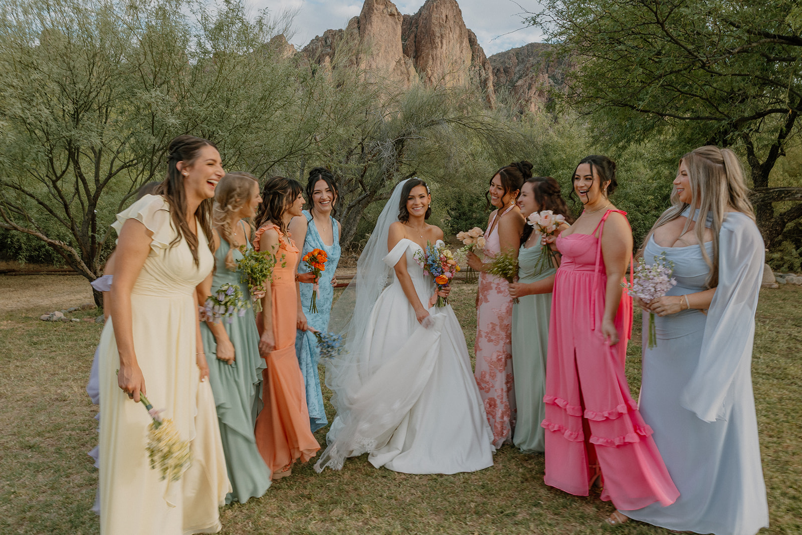 A bride posing for photos with her bridesmaids