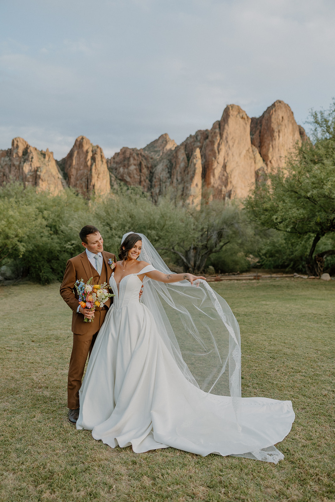 A bride and groom taking wedding photos with some of their wedding details