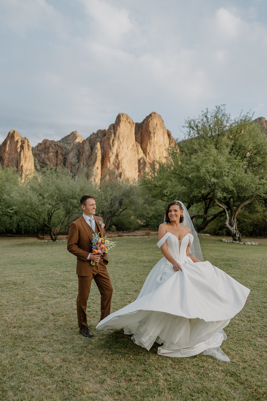 A bride and groom taking wedding photos in a field
