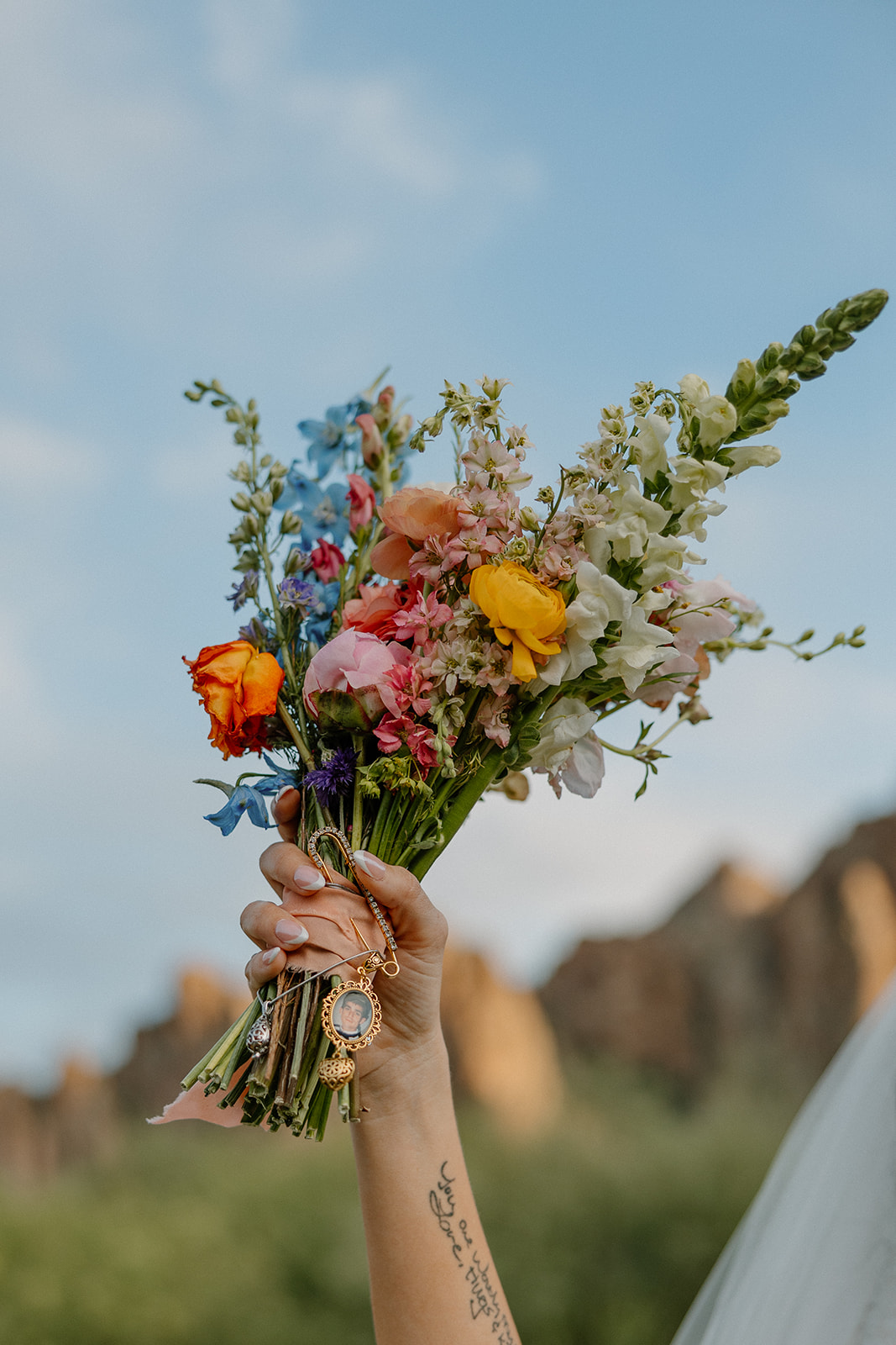 A bride holding up her bouquet for a photo of wedding details