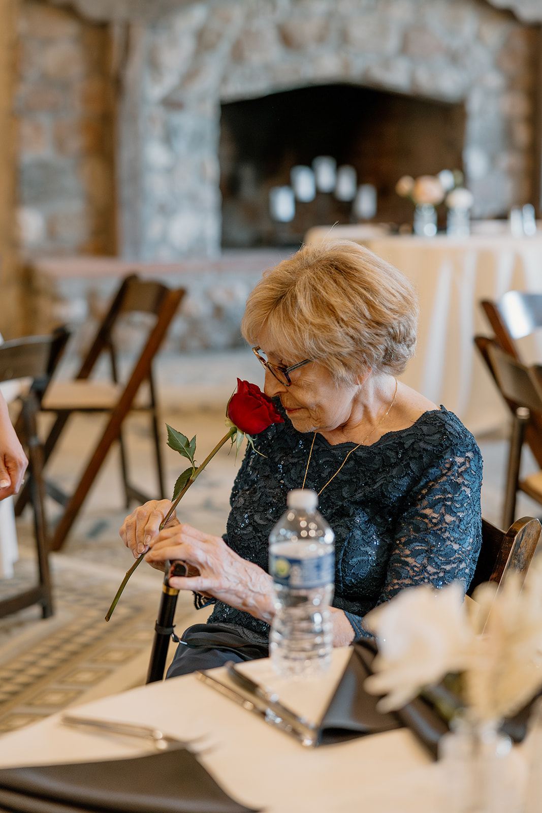 A woman smelling a rose at a wedding