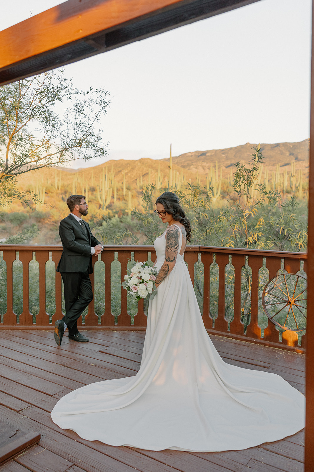 A bride and groom taking wedding photos on a terrace overlooking the desert