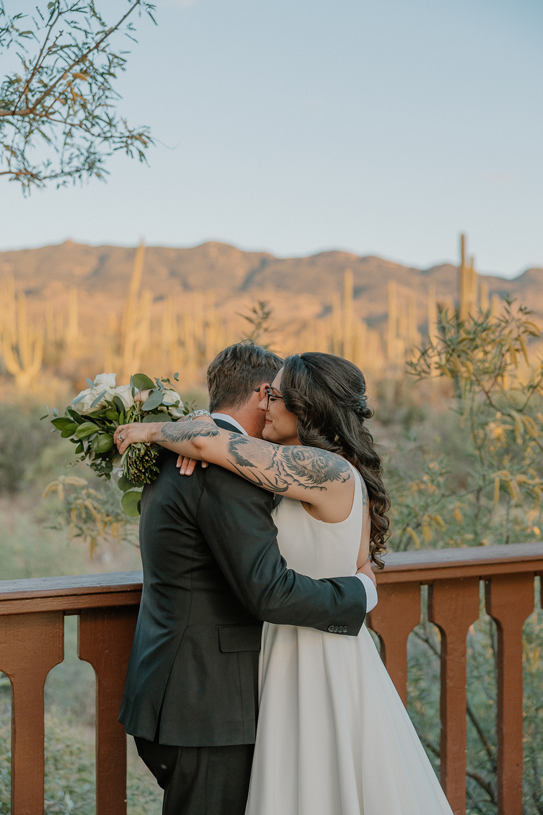 A bride and groom taking wedding photos on a terrace overlooking the desert