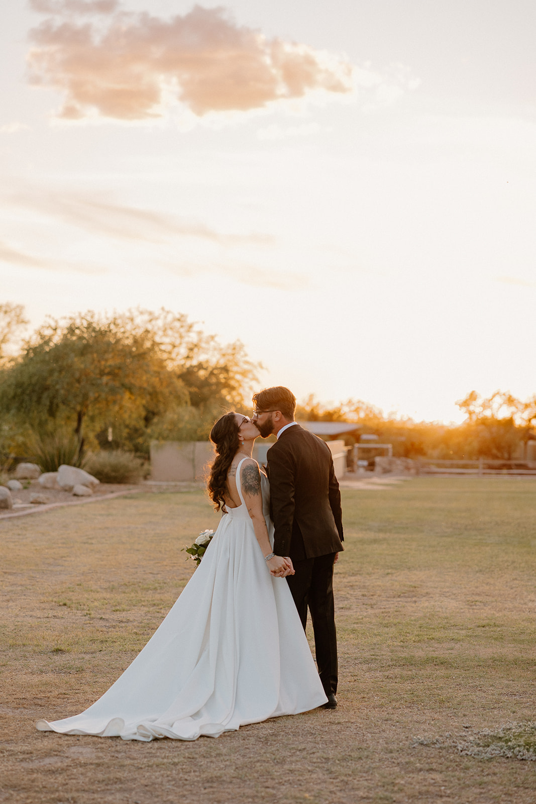 A bride and groom posing for sunset wedding photos
