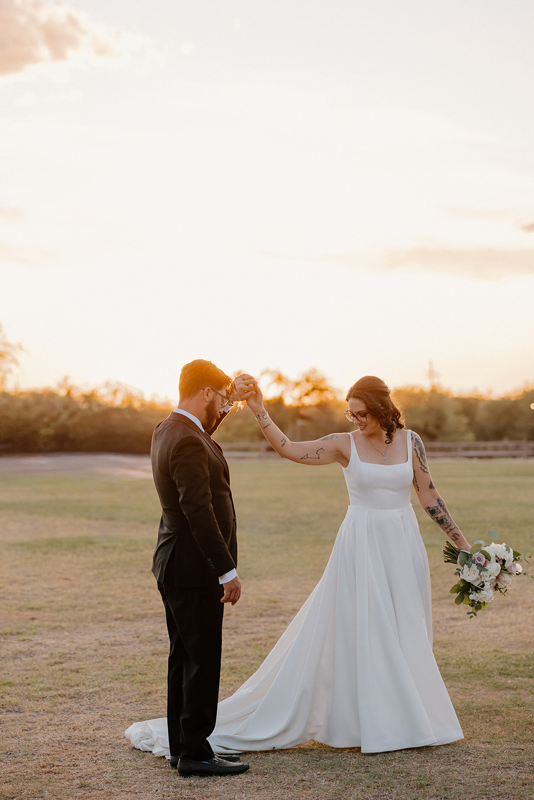A bride and groom posing for sunset wedding photos
