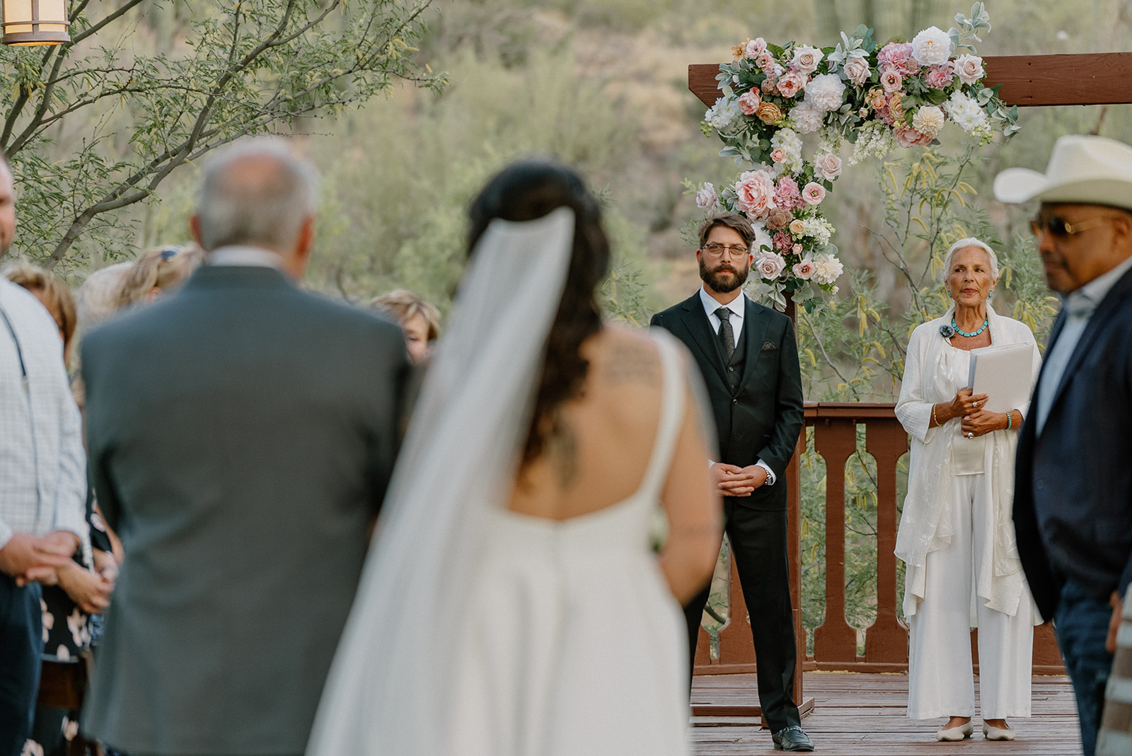 A groom watching a bride walk down the aisle