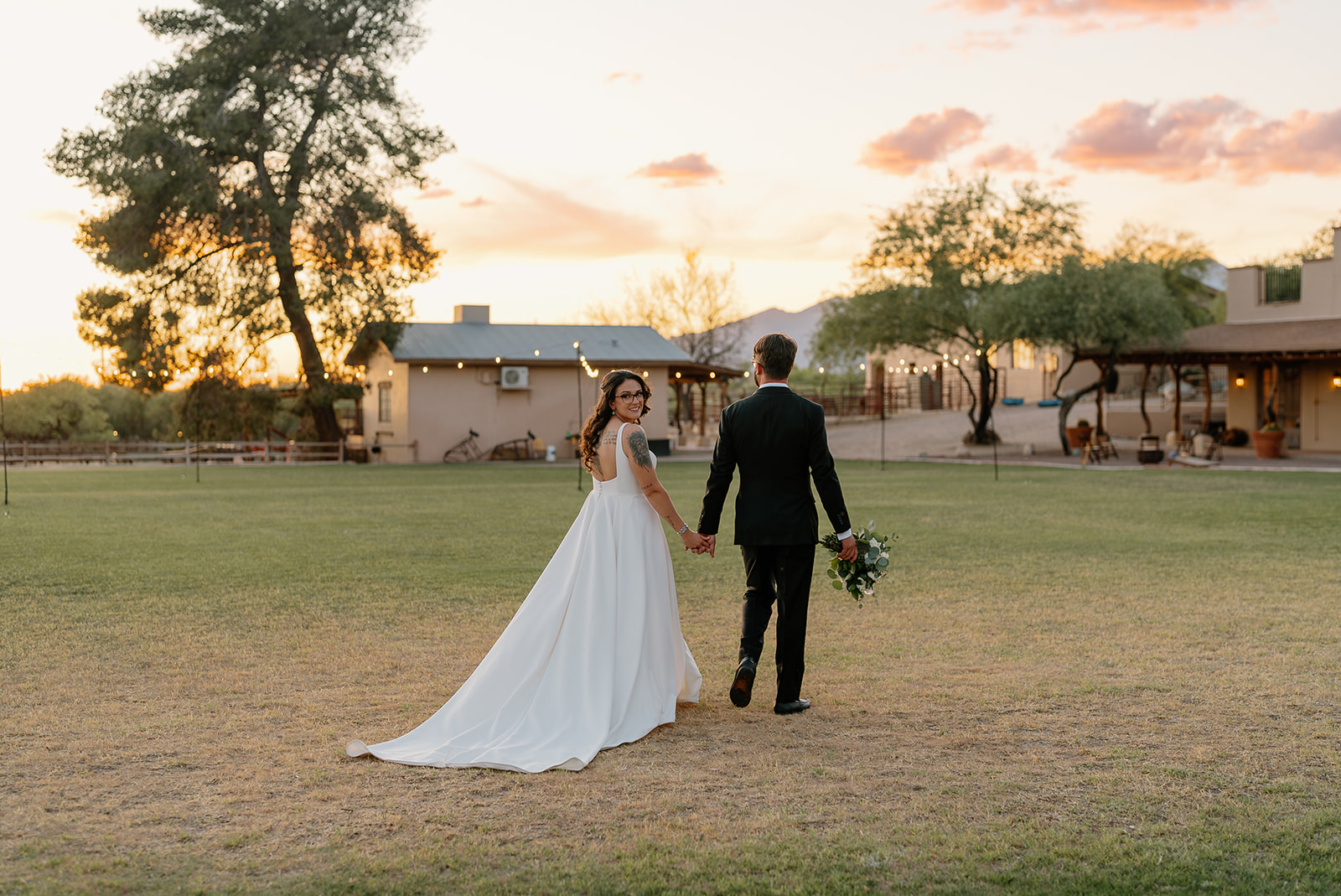 A bride and groom walking towards Tanque Verde Ranch