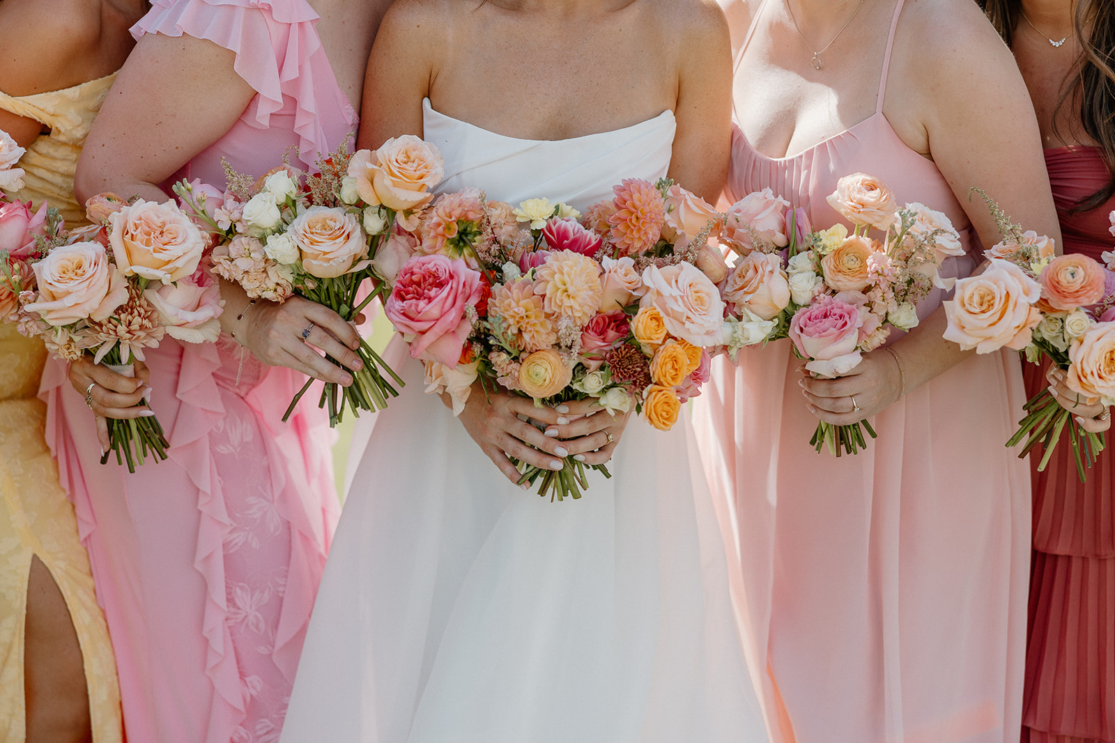 A bride and bridesmaids holding their wedding bouquets