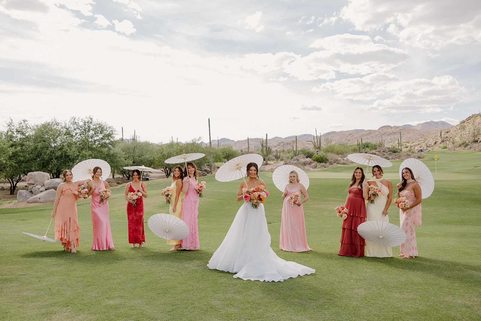 A bride and bridesmaids holding parasols