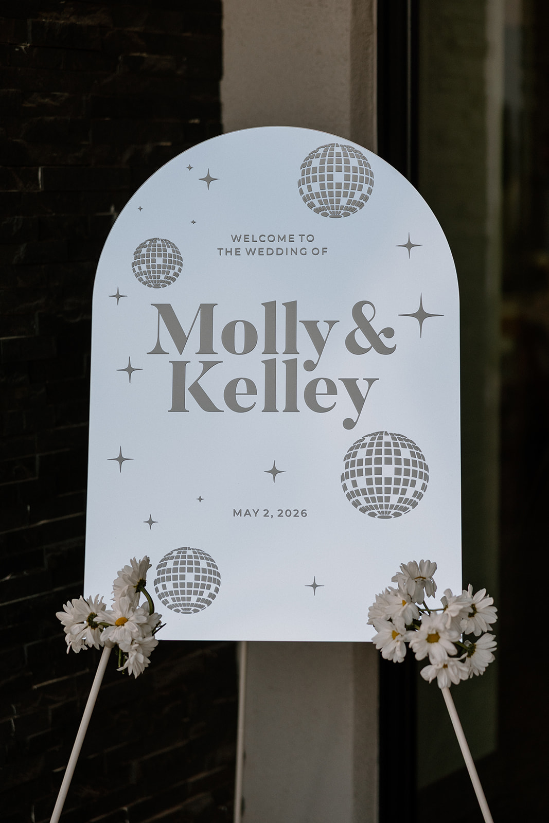 A wedding welcome sign with disco balls
