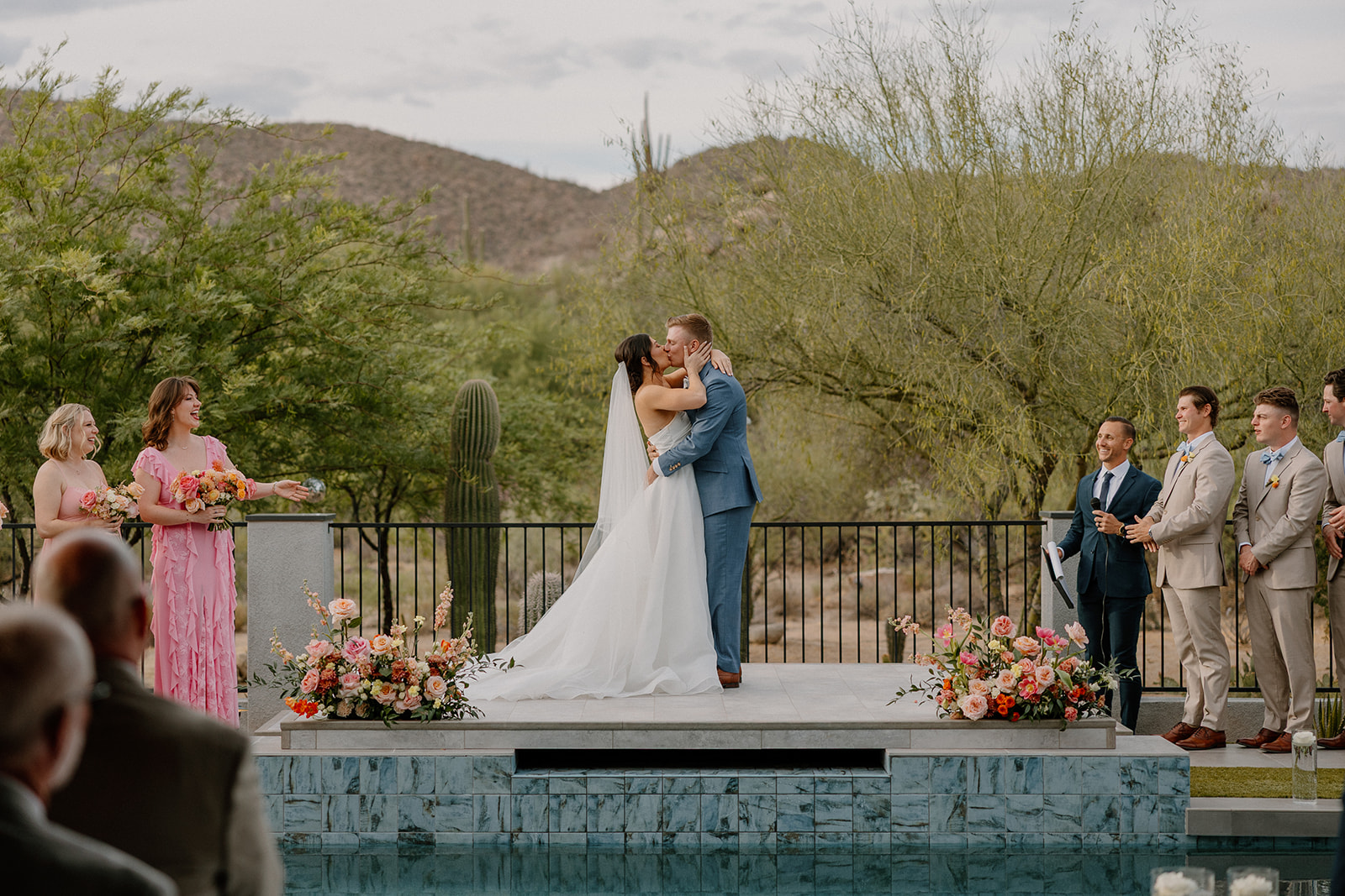 A bride and groom's first kiss at their backyard wedding ceremony