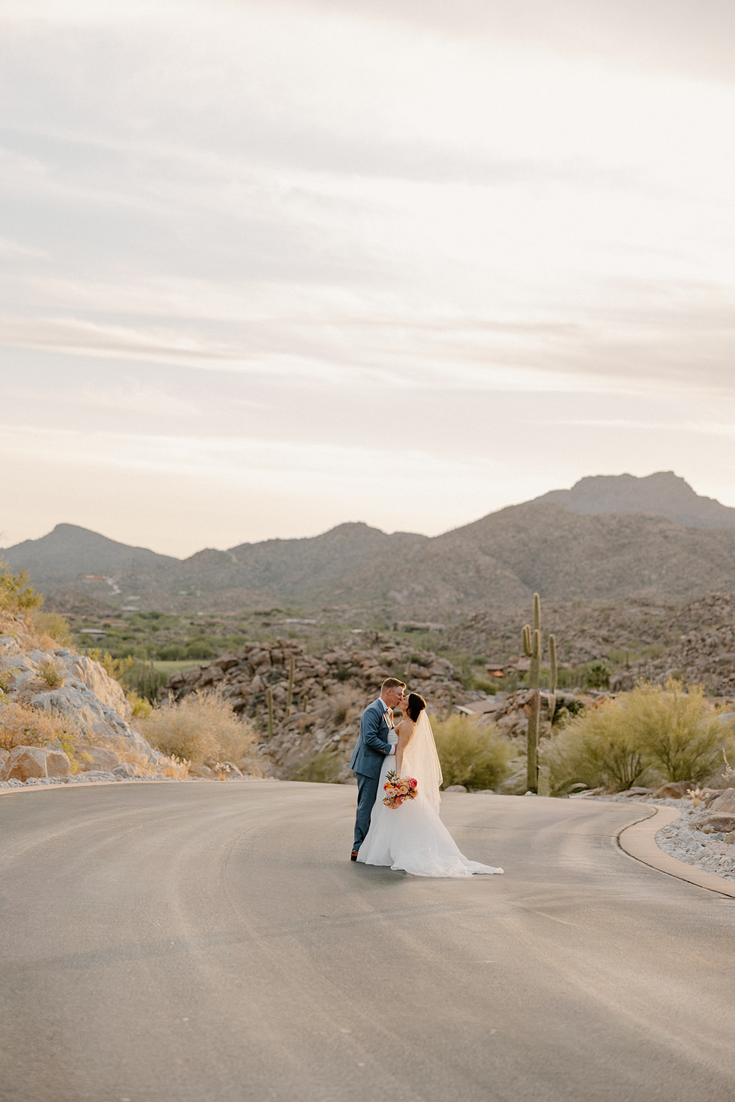 A bride and groom taking sunset wedding photos on a street