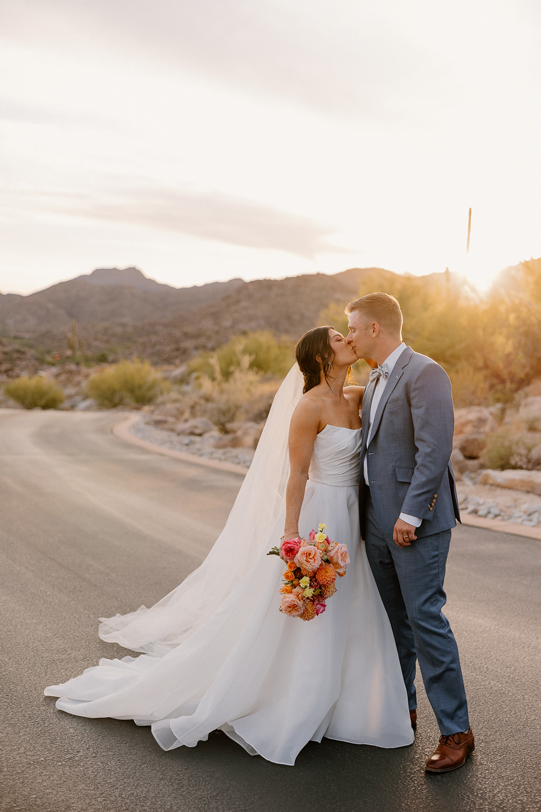 A bride and groom taking sunset wedding photos on a street