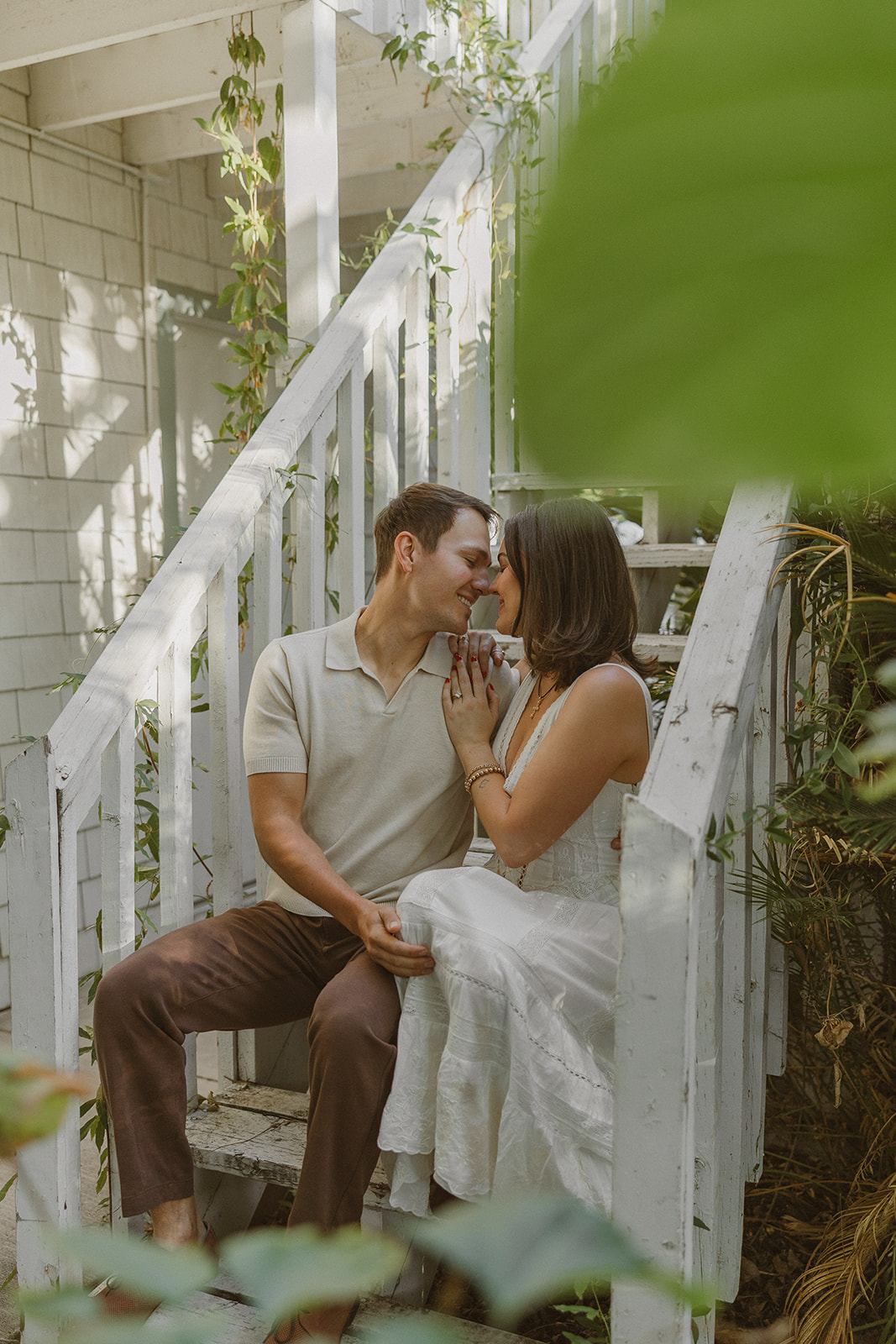 A couple sitting on stairs at the evergreen garden for engagement photos