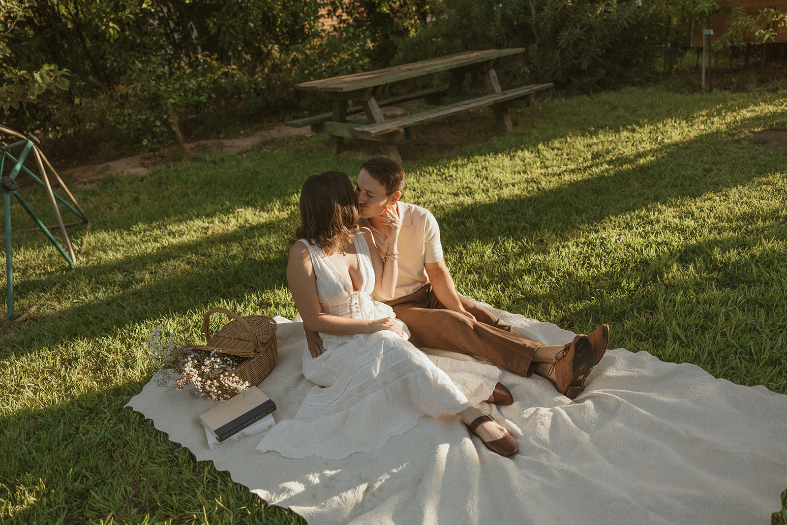 A couple at a picnic for their garden engagement photos