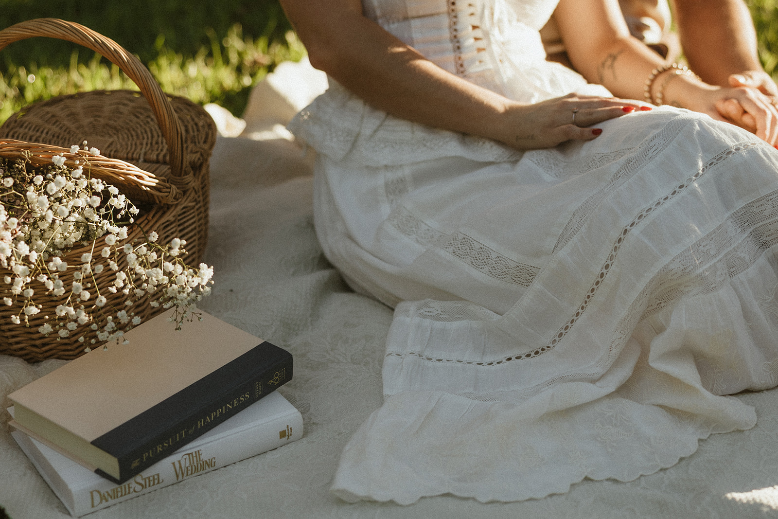 A woman's dress and books at her picnic engagement photos