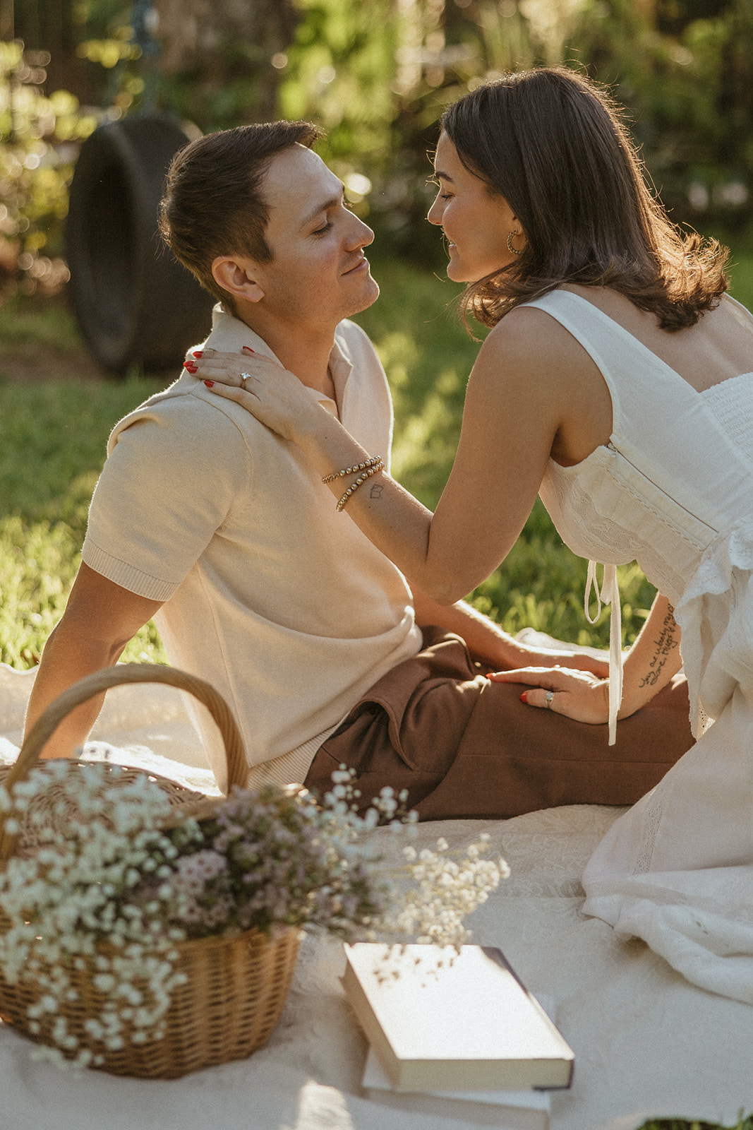 A couple kissing at their picnic engagement photos in a garden