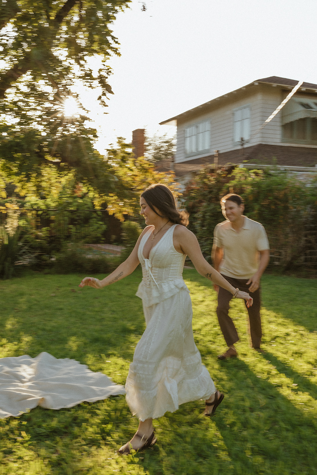 A couple running through the evergreen garden for romantic engagement photos